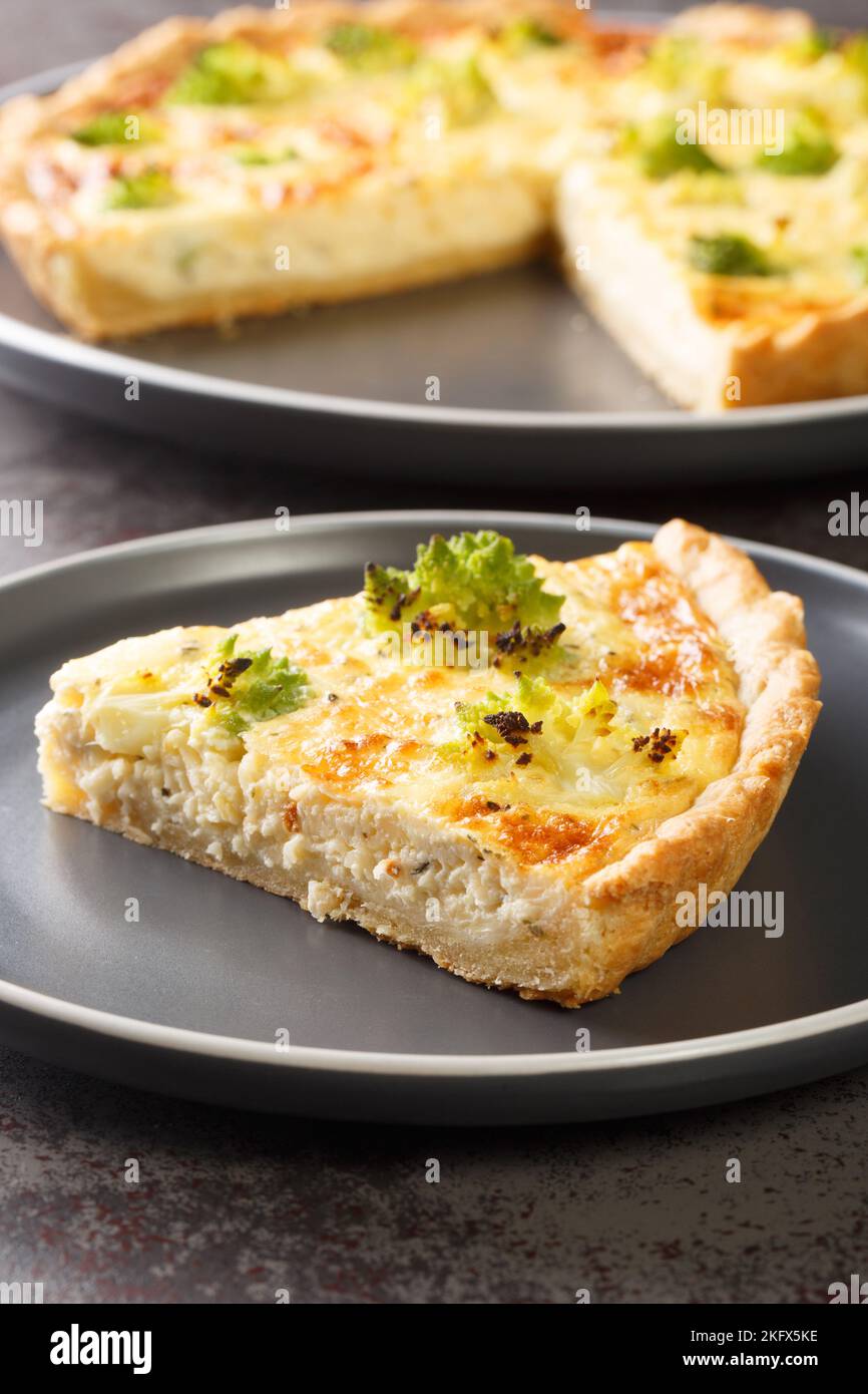 Crostata di cavolo romanesco con formaggio e uova in primo piano sul piatto del tavolo. Verticale Foto Stock