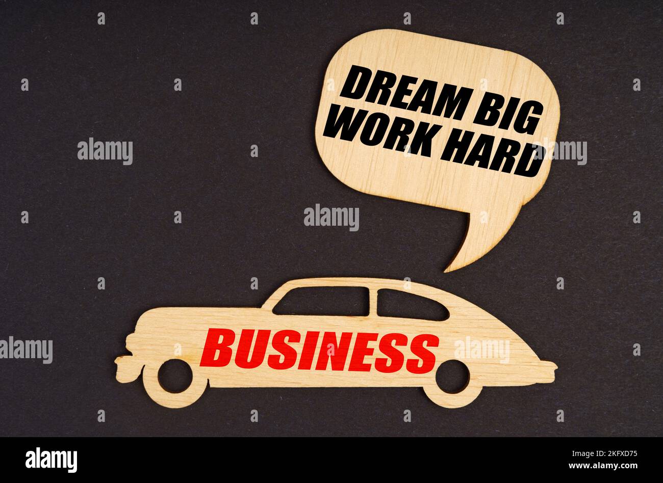 Concetto di business e finanza. Su uno sfondo nero, una macchina con l'iscrizione Business, sopra di esso un piatto con l'iscrizione - Dream Big Work Hard Foto Stock