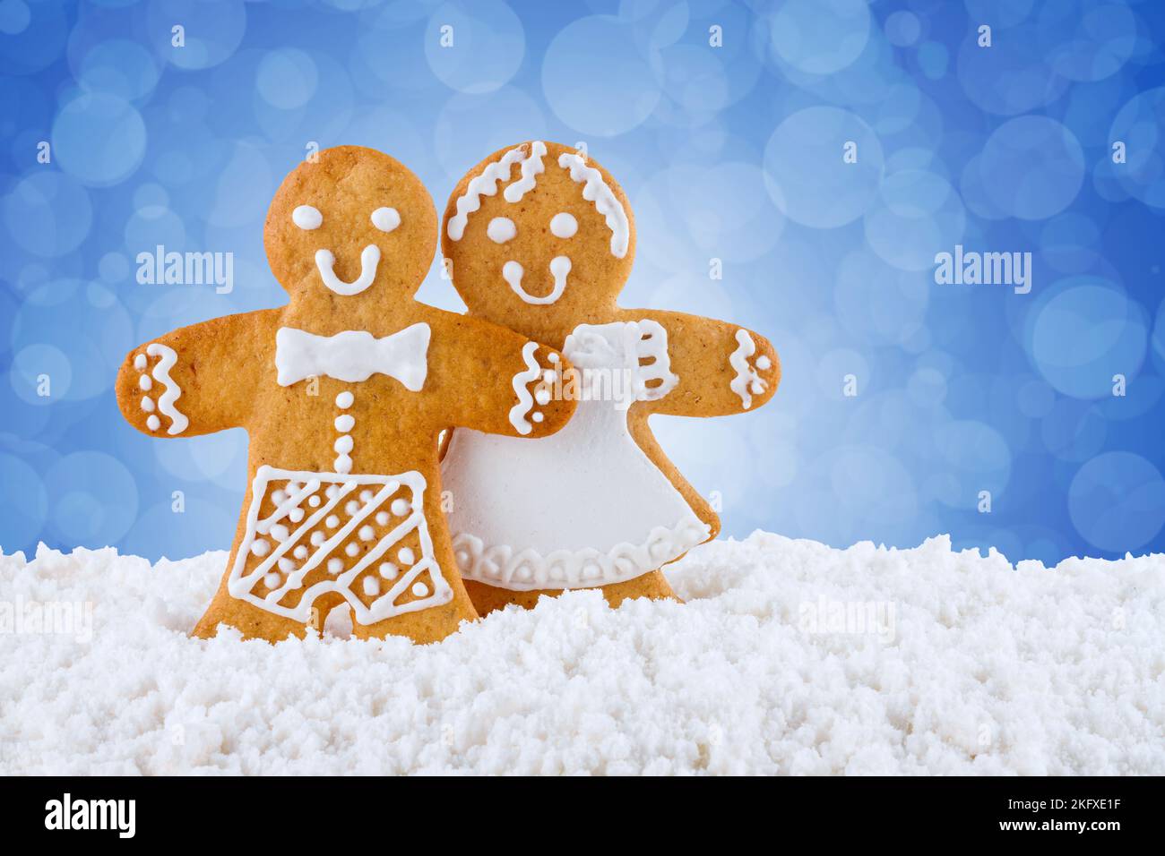 Biscotti di pan di zenzero, uomini di pan di zenzero nella neve su sfondo blu, sfondo di Natale o Capodanno, biglietto d'auguri modello Foto Stock