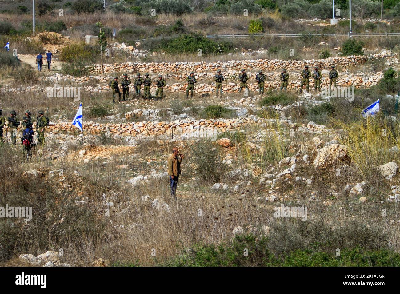 Una forza dell'esercito israeliano circonda l'insediamento di Brukhine, mentre i coloni ebrei si impadronono della terra degli agricoltori palestinesi nel villaggio di Burqin, ad ovest di Salfit, nella Cisgiordania occupata. Foto Stock