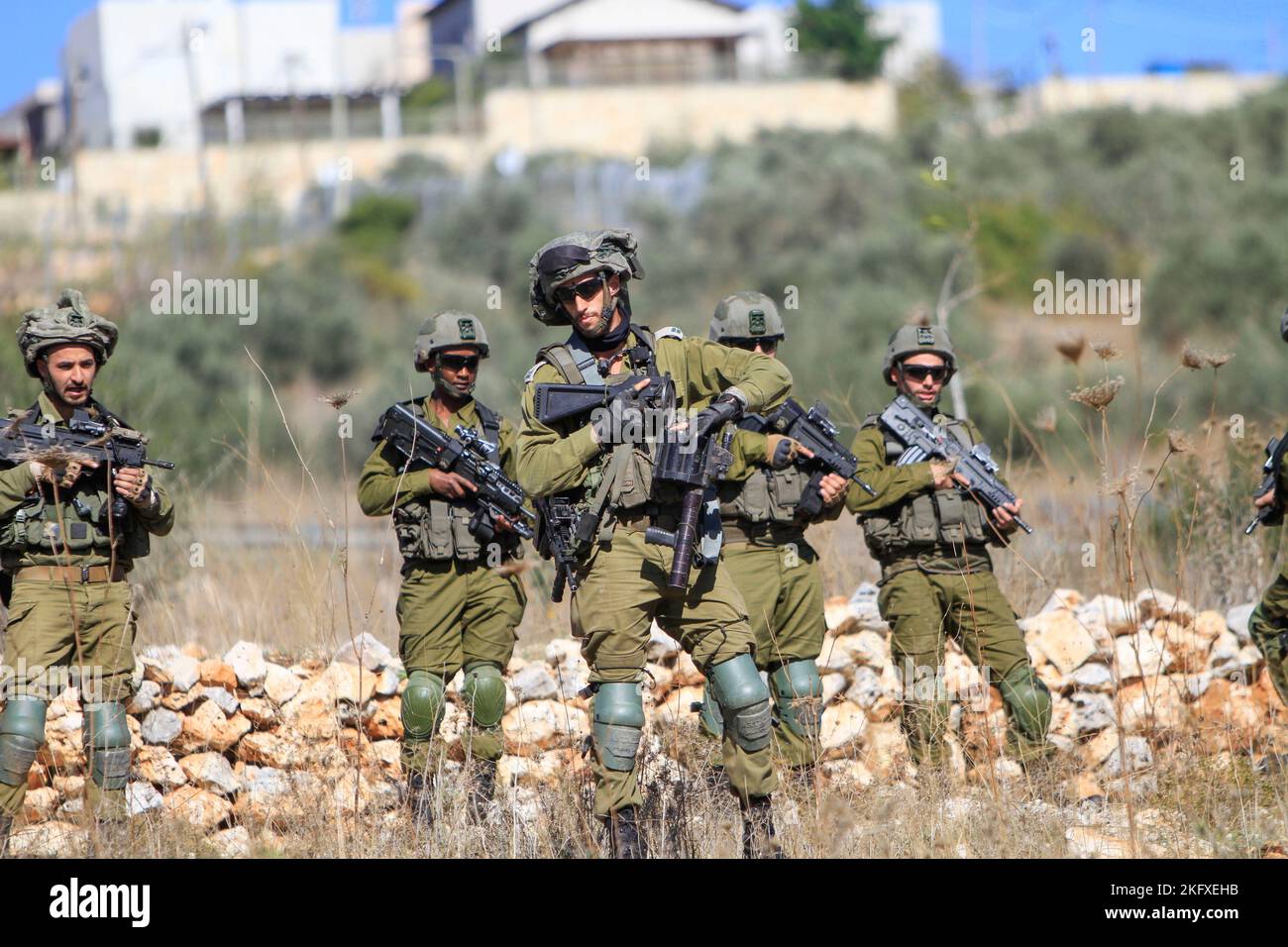 Una forza dell'esercito israeliano circonda l'insediamento di Brukhine, mentre i coloni ebrei si impadronono della terra degli agricoltori palestinesi nel villaggio di Burqin, ad ovest di Salfit, nella Cisgiordania occupata. Foto Stock