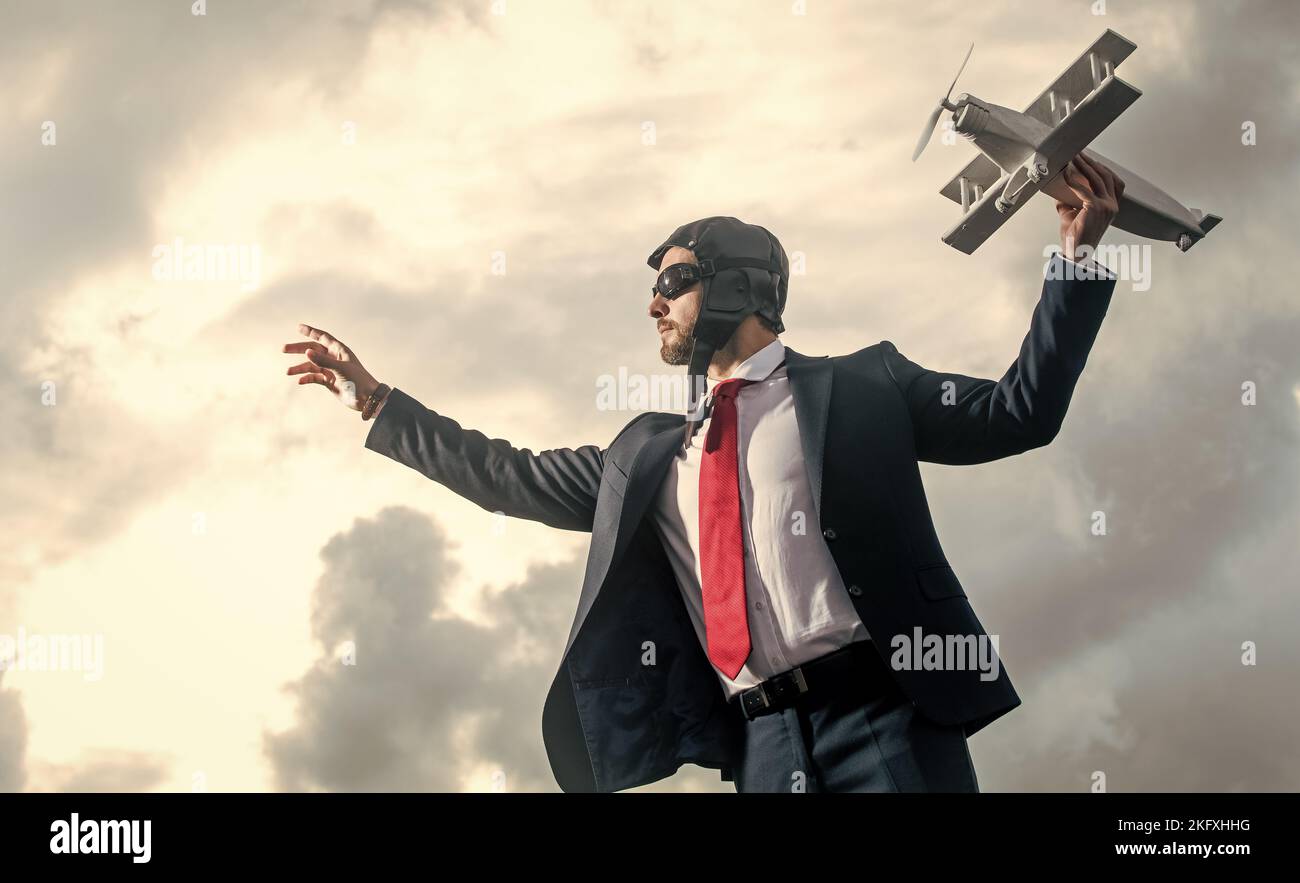 uomo d'affari in abito e cappello pilota lancia giocattolo aereo. avvio Foto Stock