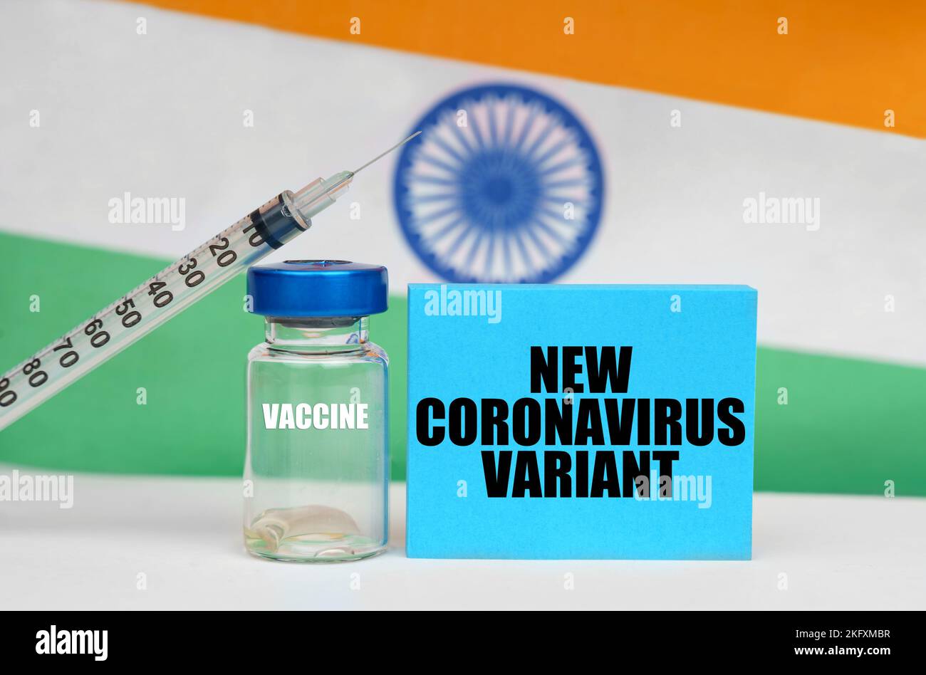 Concetto di medicina. Vaccino, siringa e piastra blu con l'iscrizione - NUOVA VARIANTE DI CORONAVIRUS. Sullo sfondo la bandiera dell'India Foto Stock