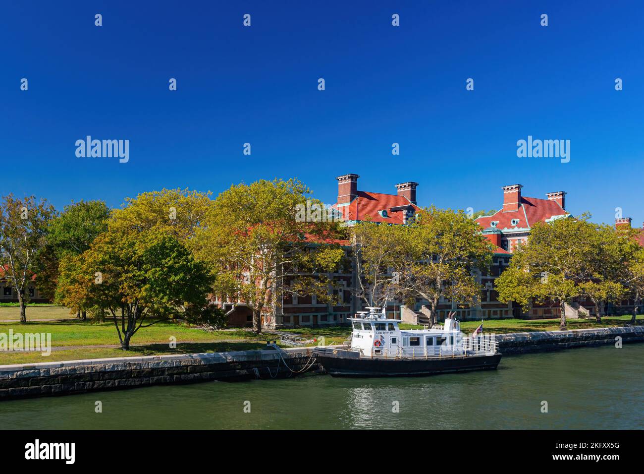 New York, 17 2014 SETTEMBRE - Vista esterna dell'edificio degli immigrati di Ellis Island con un'imbarcazione Foto Stock