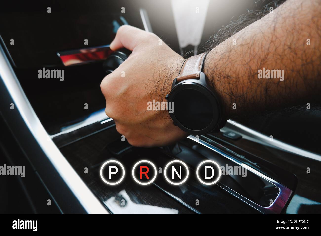 Il conducente seleziona manualmente la posizione della leva del cambio automatico e l'icona P R N D. Foto Stock