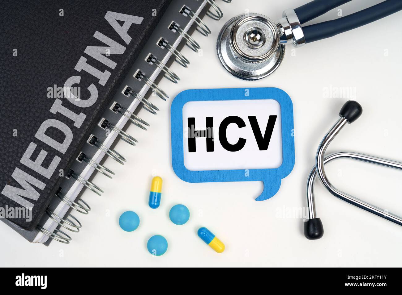 Medicina e concetto di salute. Sulla tabella è riportato uno stetoscopio, un diario e un segno con l'iscrizione - HCV Foto Stock