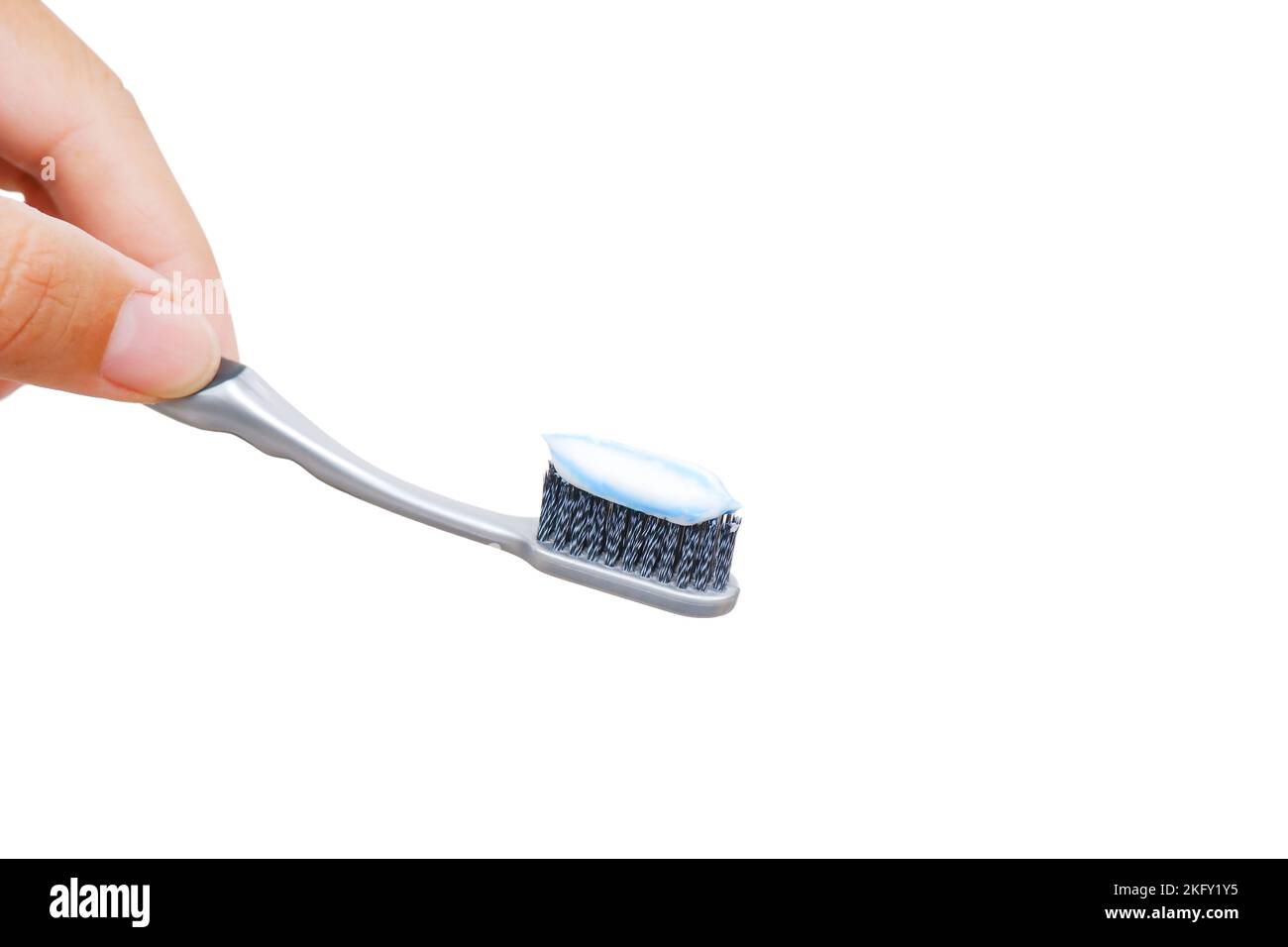 Tenendo la mano lo spazzolino grigio con un dentifricio sullo spazzolino, isolato su sfondo bianco Foto Stock