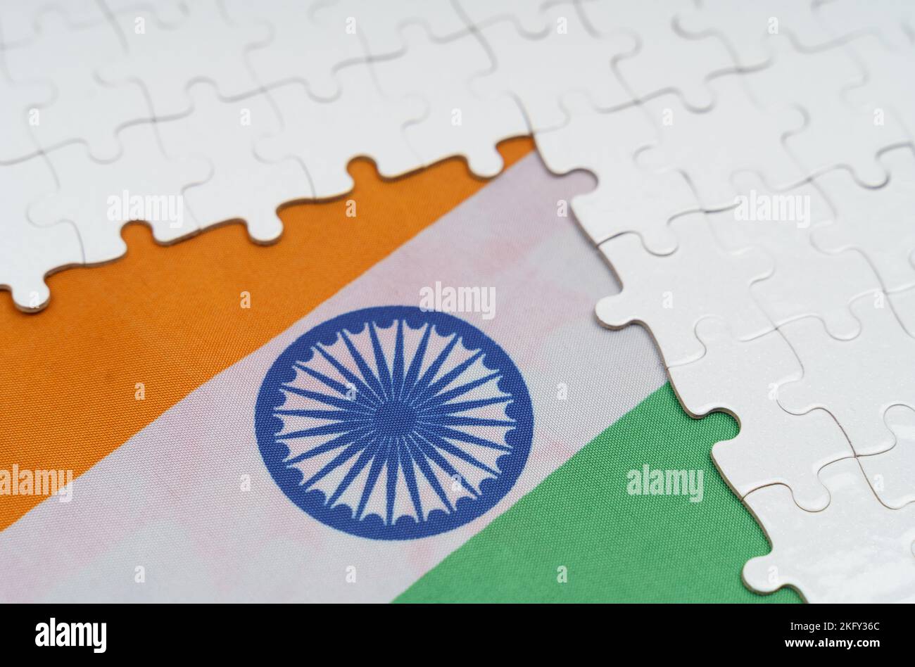 Concetto nazionale. Ci sono puzzle bianchi su un tavolo sopra la bandiera dell'India. Foto Stock