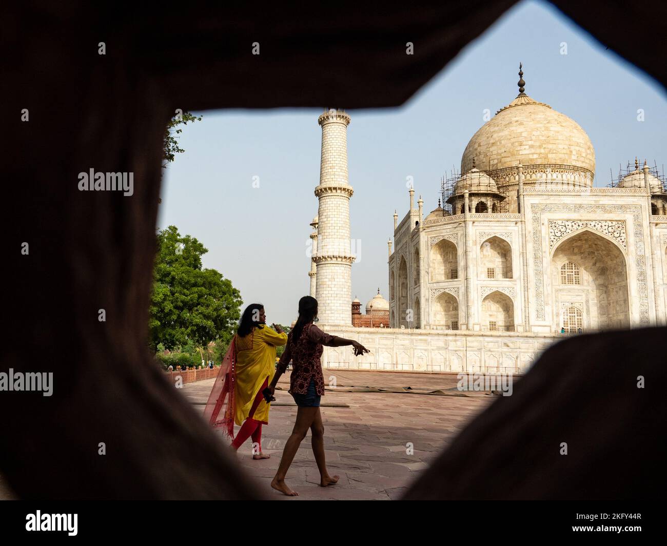 Due donne vestite in Sari sullo sfondo del Taj Mahal visto da una recinzione di openwork. AGRA, India Foto Stock