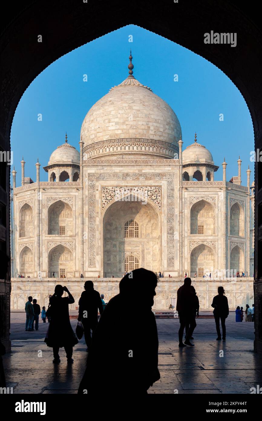 Le sagome del popolo dello sfondo Taj Mahal visto dall'arco del cancello d'ingresso. AGRA, India Foto Stock