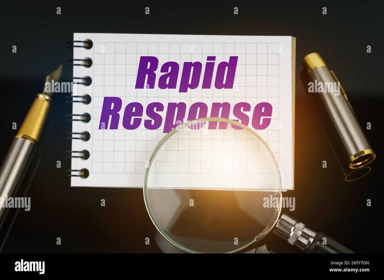 Business ed Economia. Sulla superficie nera si trova una penna, una lente d'ingrandimento e un notebook con la scritta - Rapid Response Foto Stock