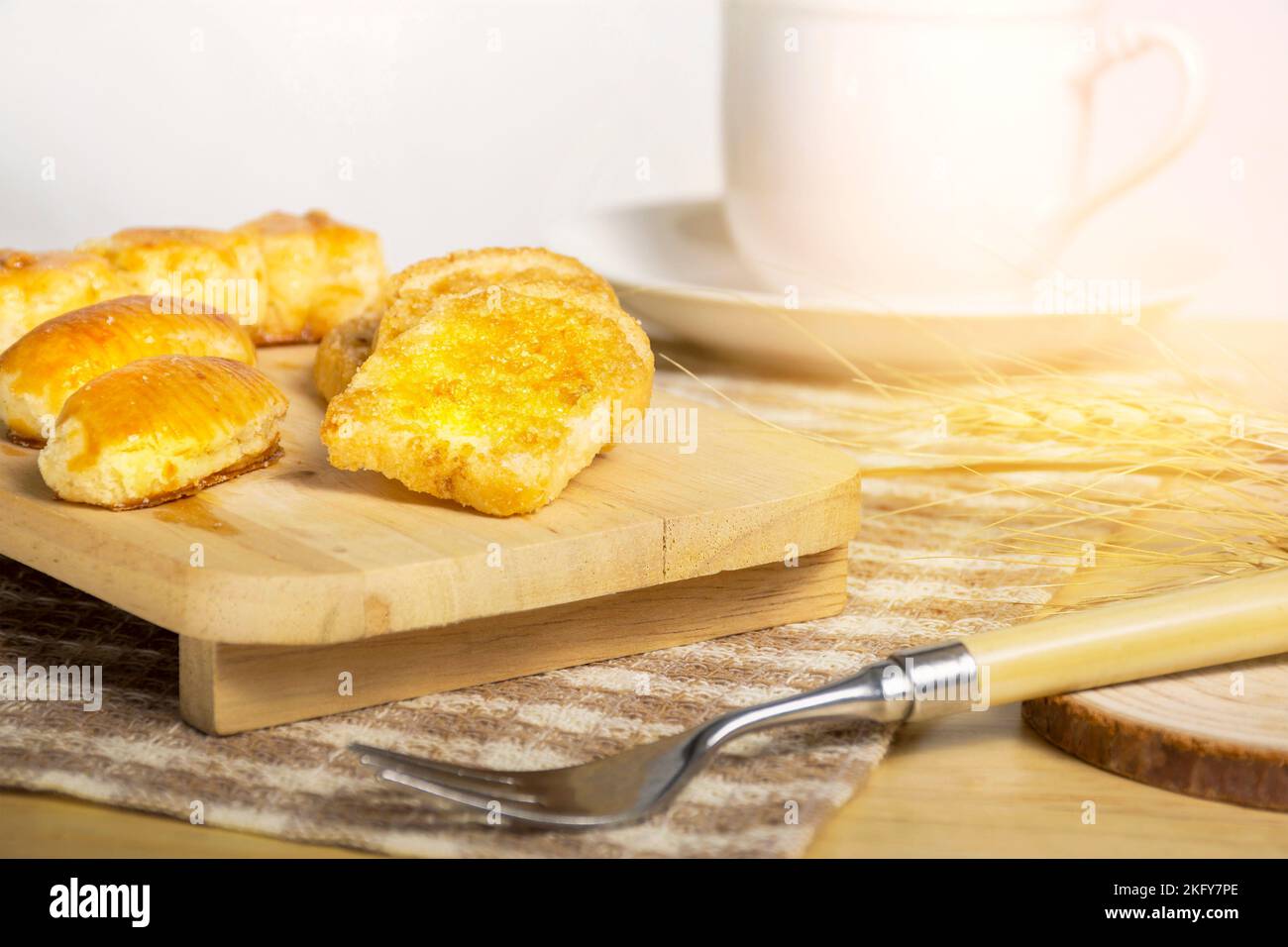 Pane croccante all'aglio con zucchero sul tavolo di legno e luce del mattino Foto Stock