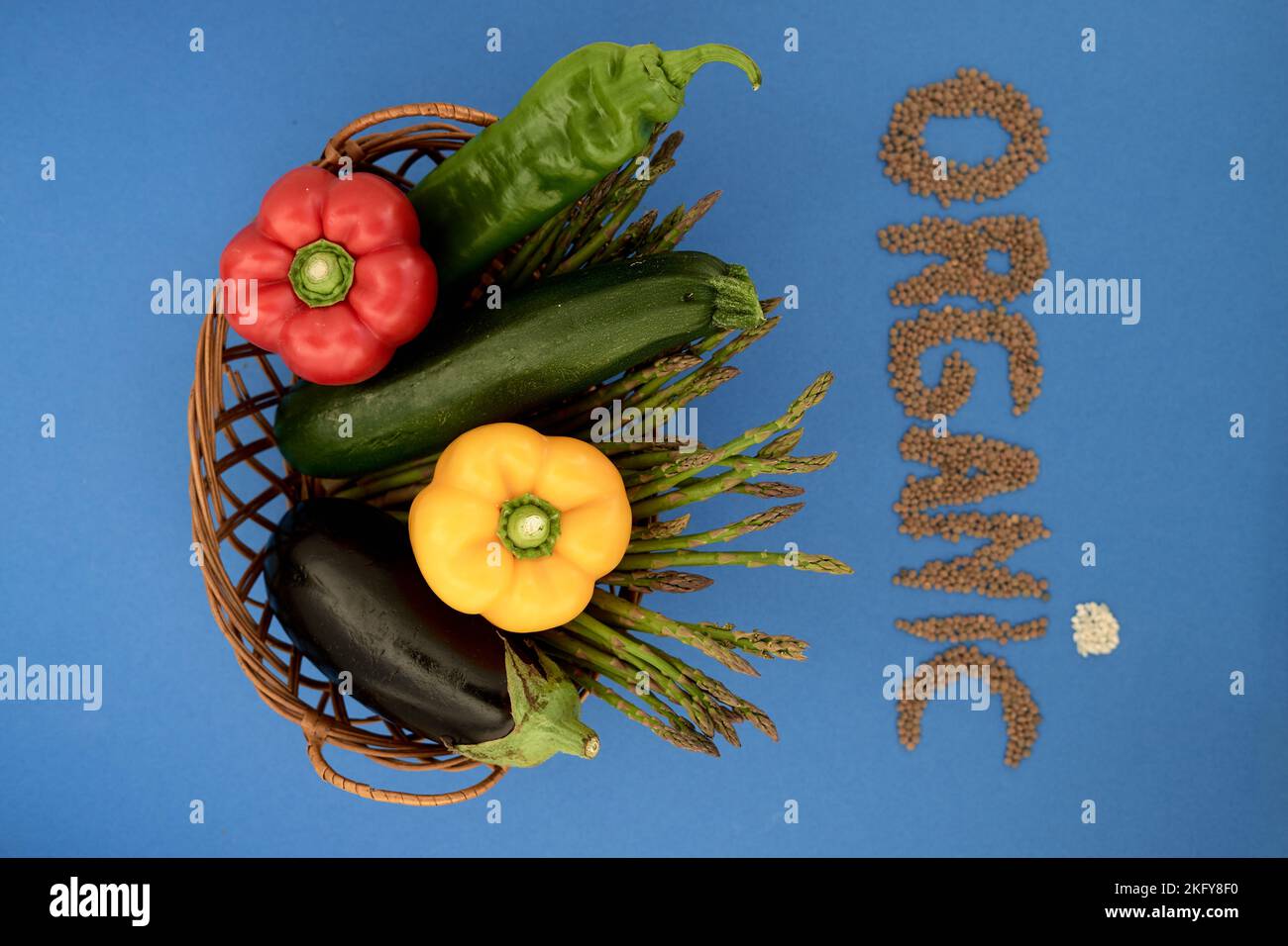 formazione della parola organica con legumi e cereali accanto ad un cesto di vimini con verdure Foto Stock