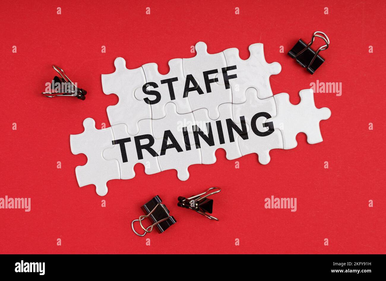 Business ed Economia. Su uno sfondo rosso, ci sono puzzle con l'iscrizione - formazione del personale Foto Stock