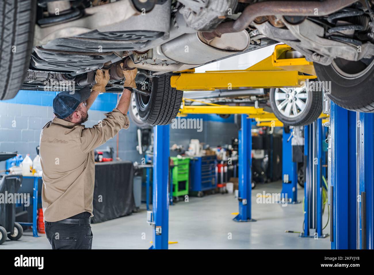 Controllo del sistema di scarico dell'auto da parte di un meccanico professionista. Manutenzione del veicolo per garantire un controllo delle emissioni adeguato. Foto Stock