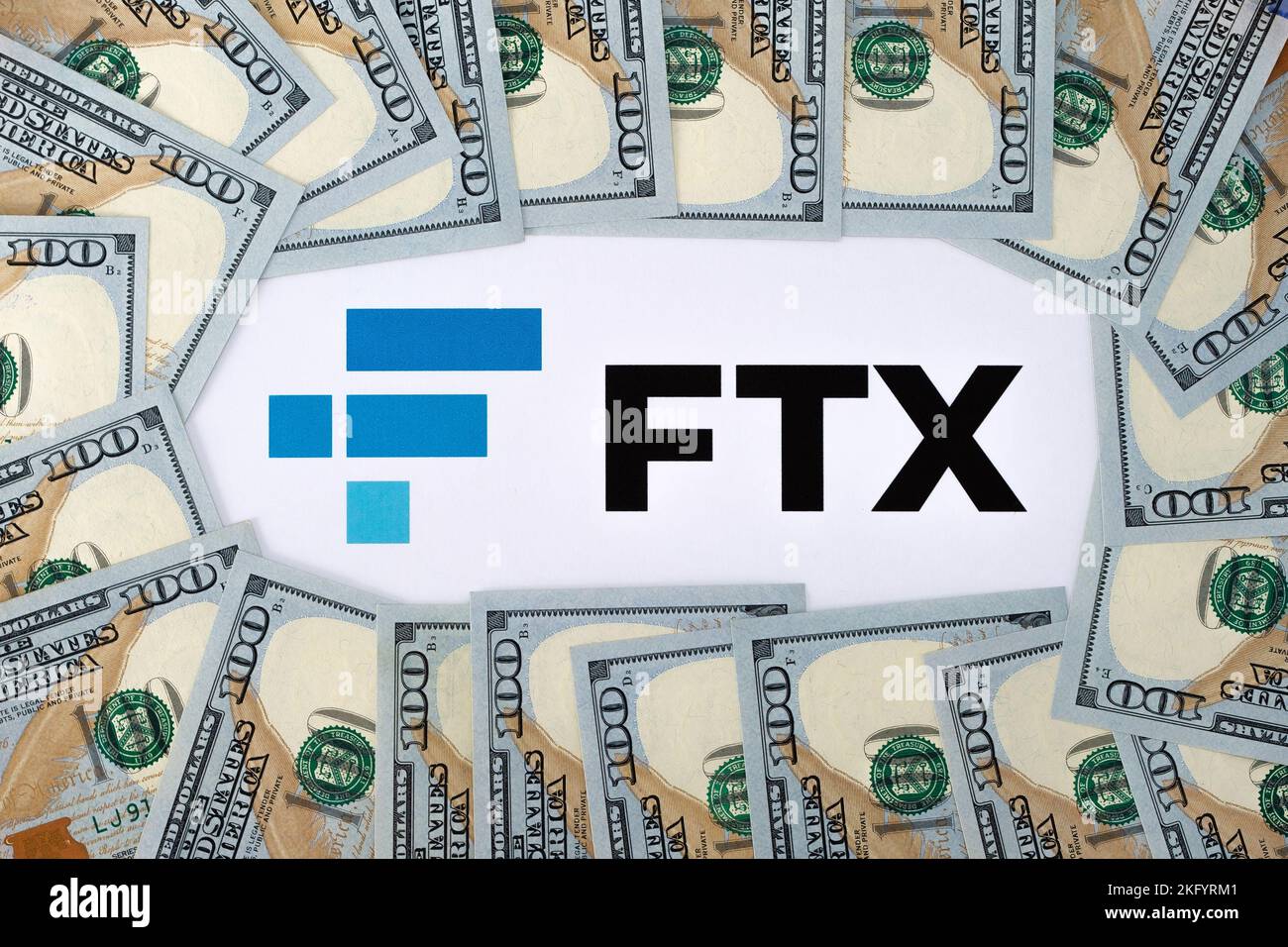 Logo FTX Cryptocurrency Exchange stampato su carta e banconote in dollari statunitensi. Concetto di fallimento aziendale e di debito. Stafford, United Kindom Foto Stock