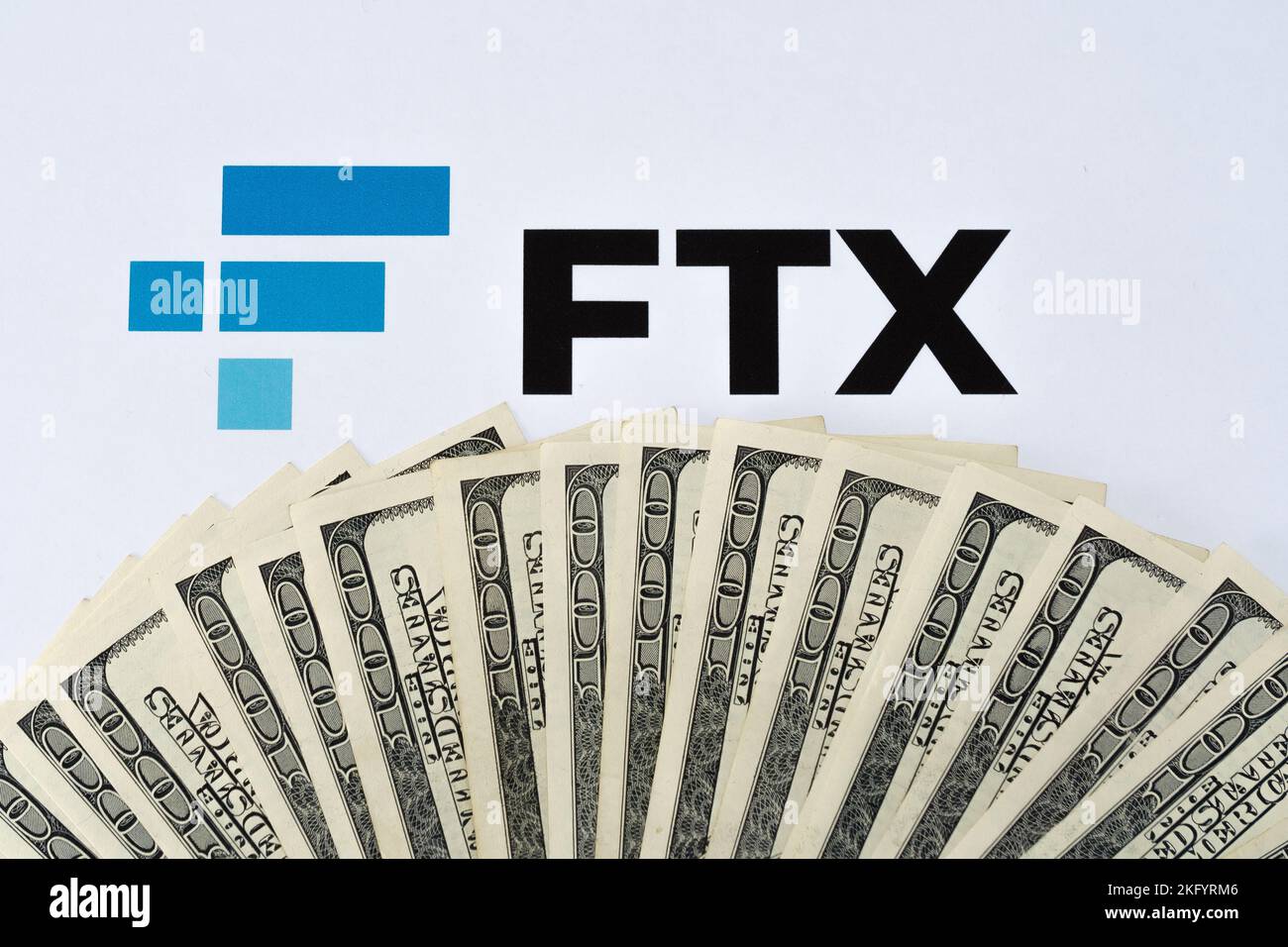 Logo FTX Cryptocurrency Exchange stampato su carta e banconote in dollari statunitensi. Concetto di fallimento aziendale e di debito. Stafford, United Kindom Foto Stock