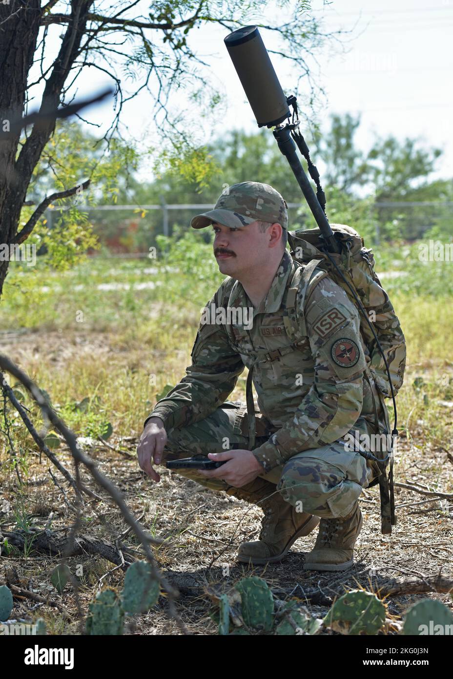 Personale dell'aeronautica degli Stati Uniti Sgt. Joshua Elrod, 316th istruttore di squadrone di addestramento, accoccoli all'ombra per leggere il display di antenne di terra standard della bestia durante un esercizio di ricerca di direzione alla base dell'aeronautica di Goodfellow, Texas, 19 ottobre 2022. I membri dell'aeronautica sono stati invitati a partecipare all'esercizio per esporli alla guerra elettronica a livello tattico e contestualizzare le nuove informazioni insegnate durante il corso di intelligenza elettronica. Foto Stock