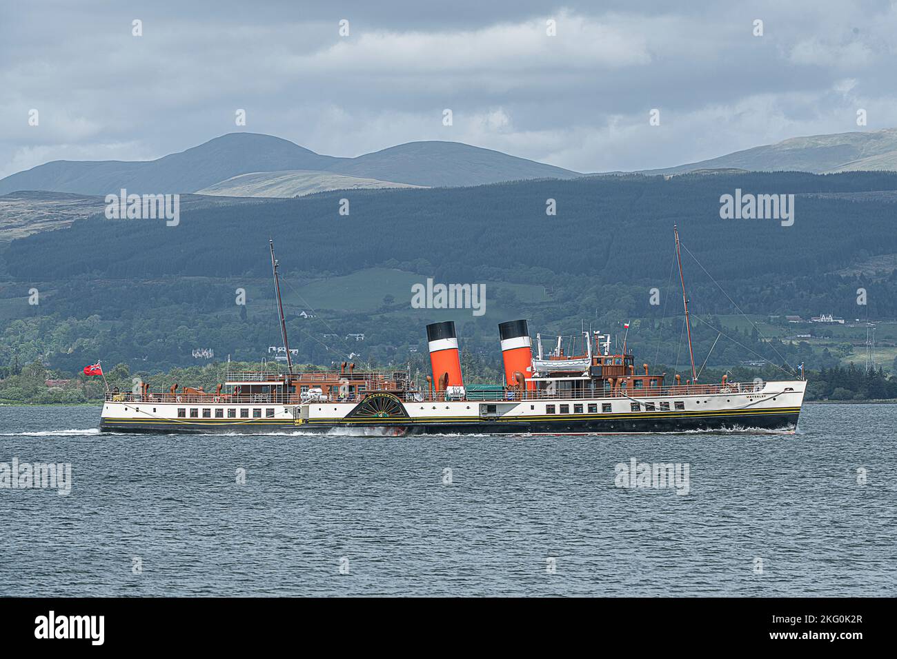 Il PS Waverly navigando al largo di Esplanade, Greenock, Scozia contro le montagne in una giornata nuvolosa Foto Stock