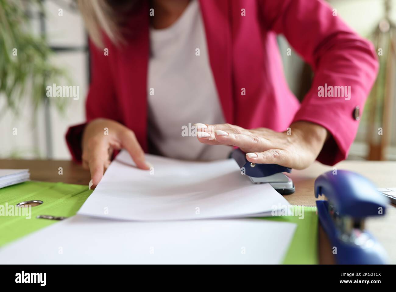 Foratura a mano femmina con punzonatrice nei documenti in ufficio Foto Stock