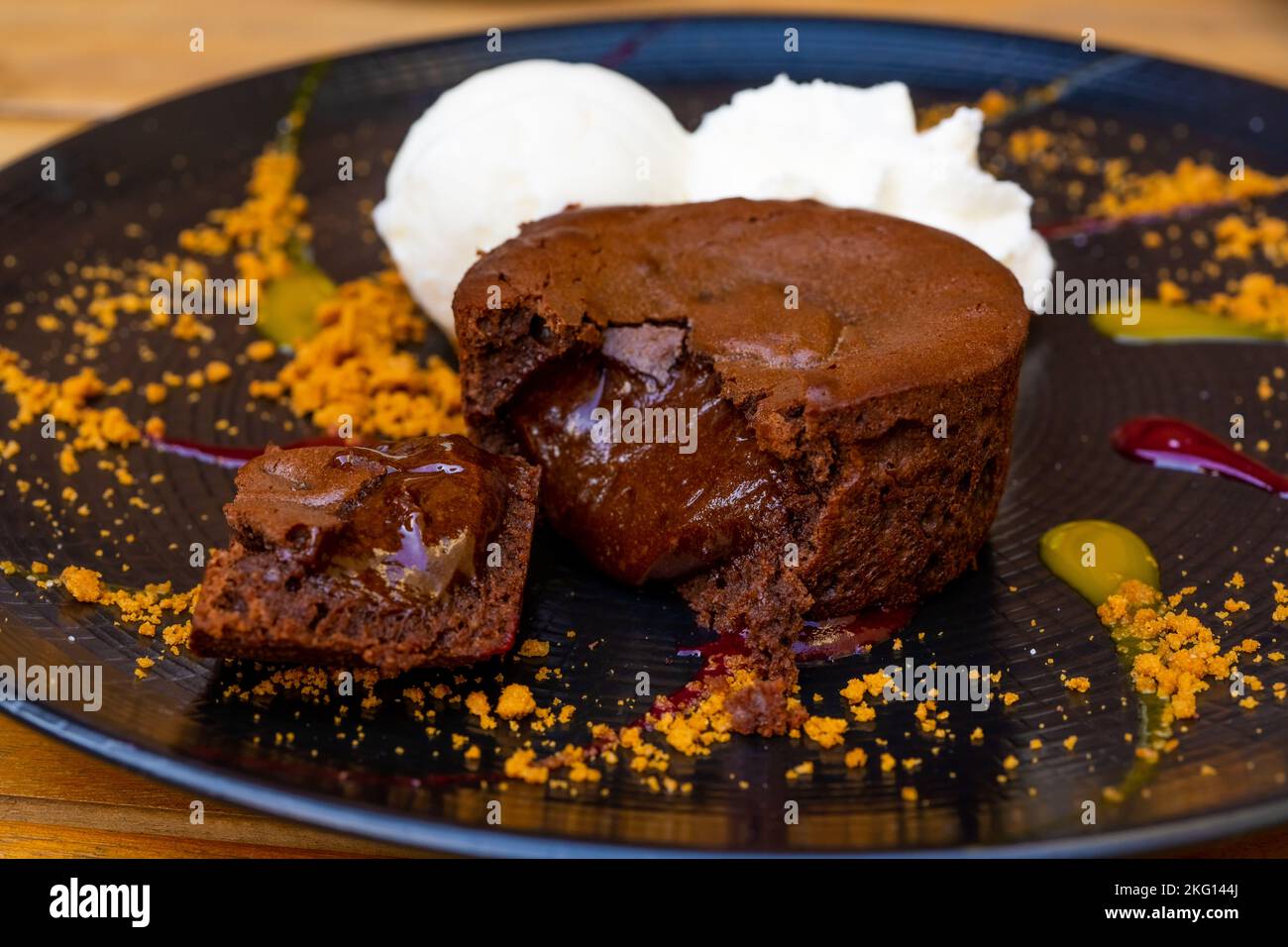 Piatto di delizioso dolce caldo torta al cioccolato fondente servito con palle di gelato. Torta di lava su un piatto decorato. Foto di alta qualità Foto Stock