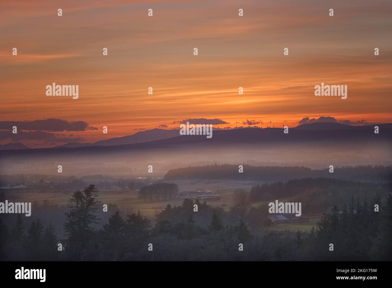 Tramonto invernale con lontano parco eolico, Scozia Foto Stock
