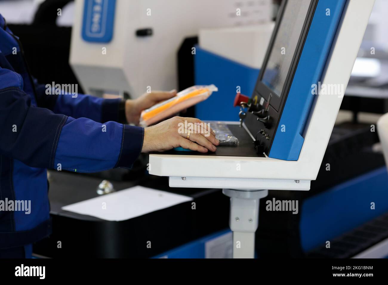 Operatore alla console di controllo della macchina da taglio laser CNC. Messa a fuoco selettiva. Foto Stock