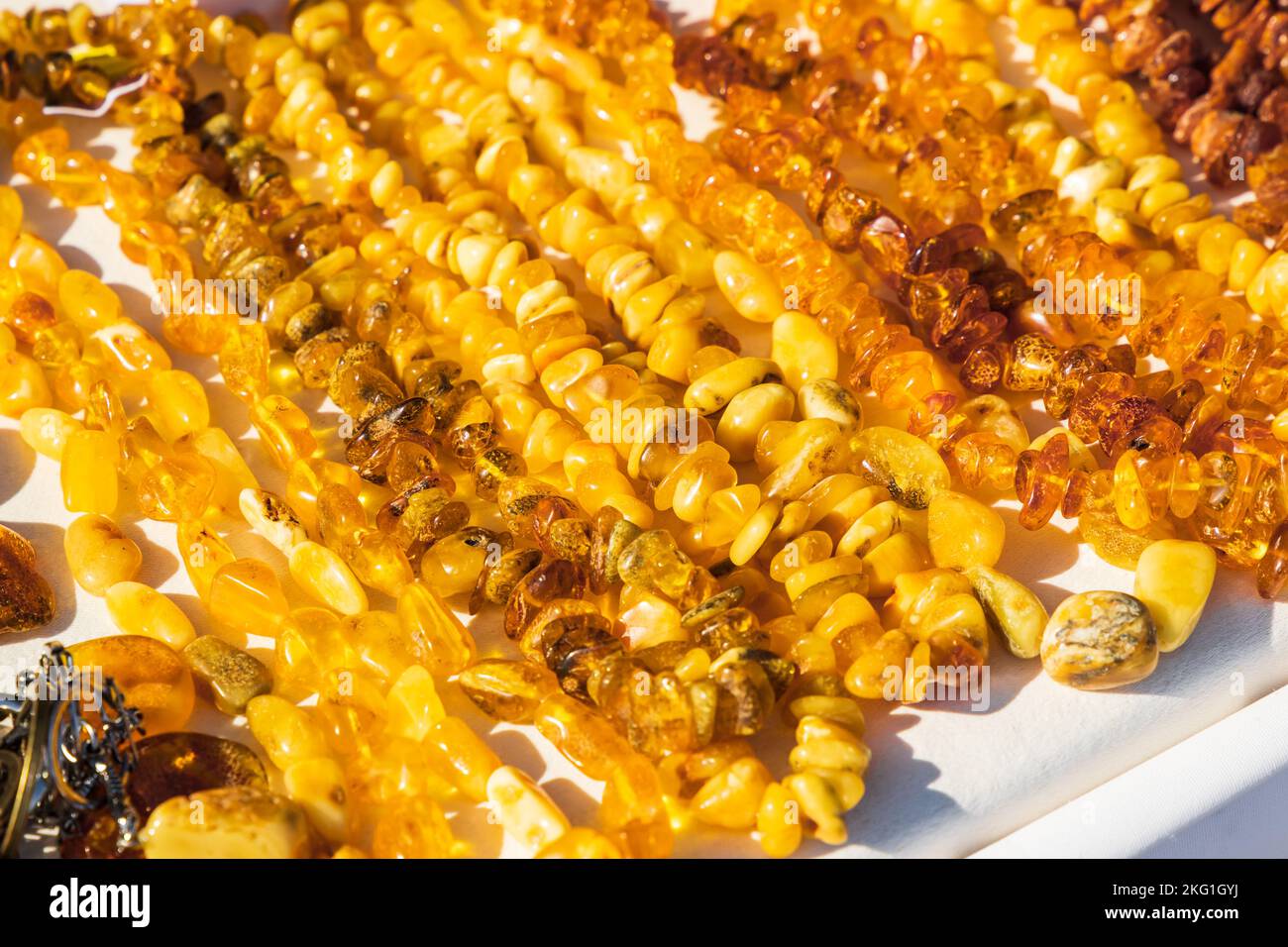 Le perle di ambra si stendano sul banco in una giornata di sole Foto Stock