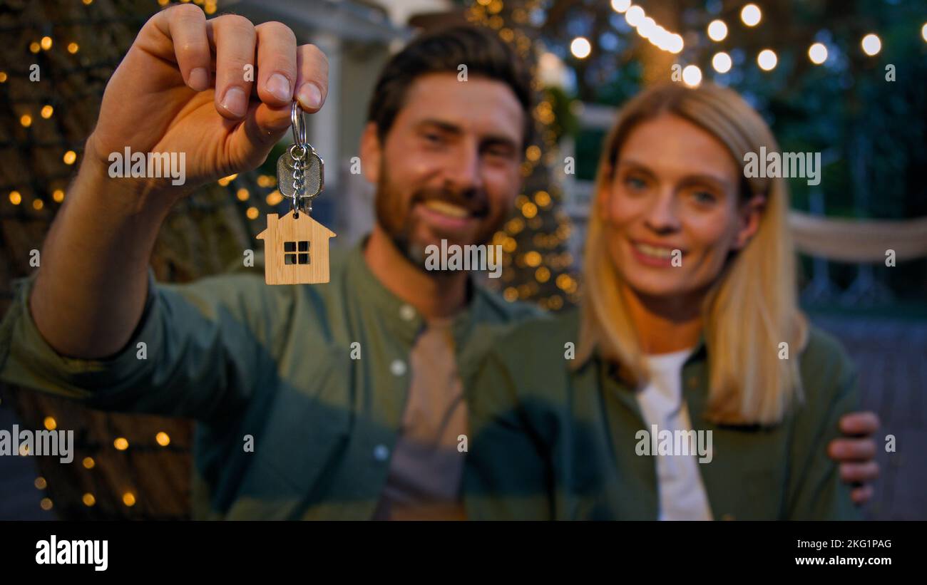 Ritratto all'aperto caucasico felice in amore coppia sposi sposi abbracciando cocdling mostrando mazzo di chiavi a nuovo immobile della casa felice con l'acquisto Foto Stock