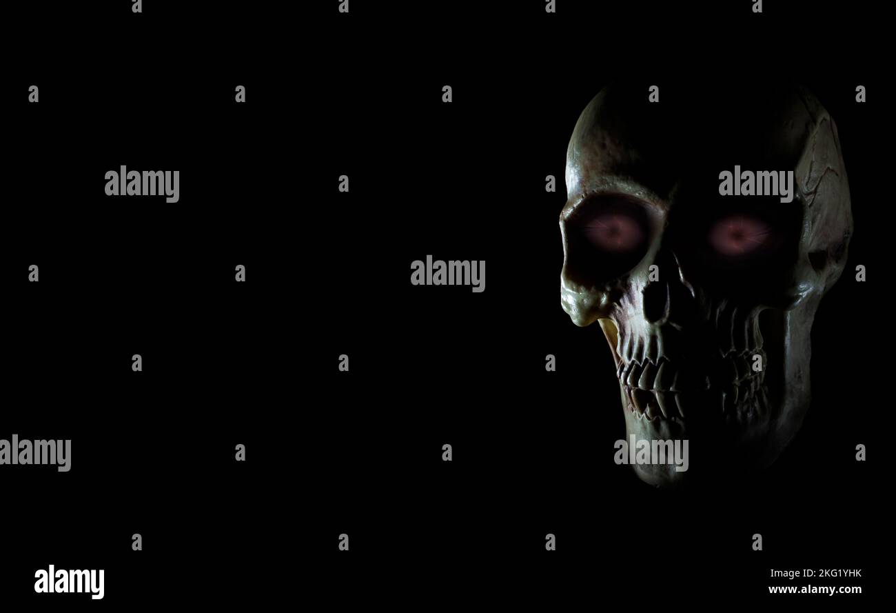 Cranio umano con occhi viola incandescente e spazio per la copia su nero Foto Stock