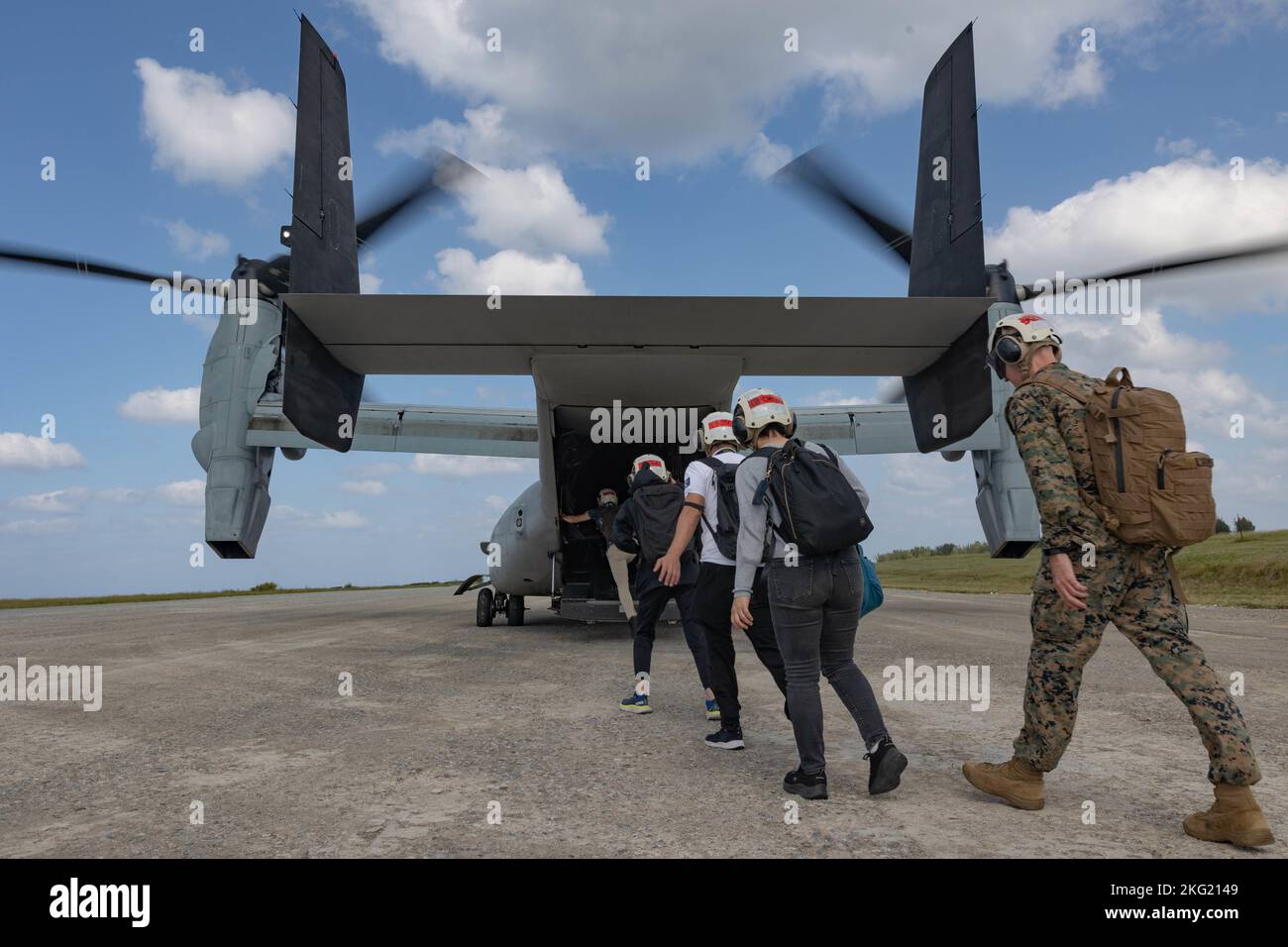 U.S. Marines with III Marine Expeditionary Force, Japan Ground Self-Defense Force members, and Okinawan media represents board an MV-22 Osprey with Marine Medium Tiltrotor Squadron 265, Marine Aircraft Group 36, 1st Marine Aircraft Wing, at IE Shima, Okinawa, Japan, Oct 24, 2022. III MEF ha ospitato un seminario di media per i rappresentanti dei media di Okinawan per fornire una migliore comprensione di ciò che III MEF fa al fine di migliorare le relazioni con la loro nazione ospitante. I rappresentanti dei media hanno avuto l'opportunità di volare su aerei militari, osservare le gamme di fuoco vivo e visitare la giungla Warfa Foto Stock