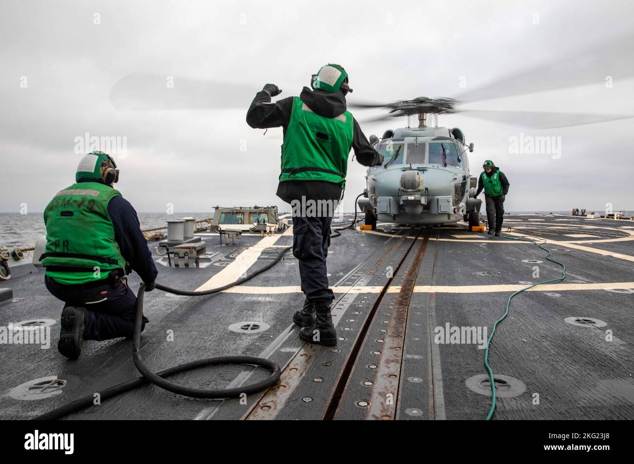MAR BALTICO (ott 24, 2022) i marinai preparano un elicottero MH-60R Seahawk, attaccato all'Helicopter Maritime Strike Squadron (HSM) 79, per il decollo sul ponte di volo del cacciatorpediniere missilistico guidato di classe Arleigh Burke USS Roosevelt (DDG 80), 24 ottobre 2022. Roosevelt si trova in una distribuzione programmata nell'area operativa delle forze Navali USA in Europa, impiegata dalla U.S. Sesta flotta per difendere gli interessi degli Stati Uniti, alleati e partner. Foto Stock