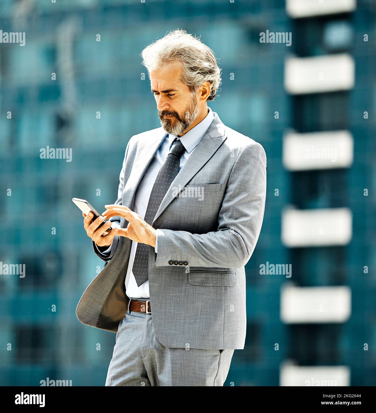 uomo d'affari uomo d'affari senior tecnologia smartphone comunicazione telefono edificio ufficio maturo connessione telefono cellulare Foto Stock