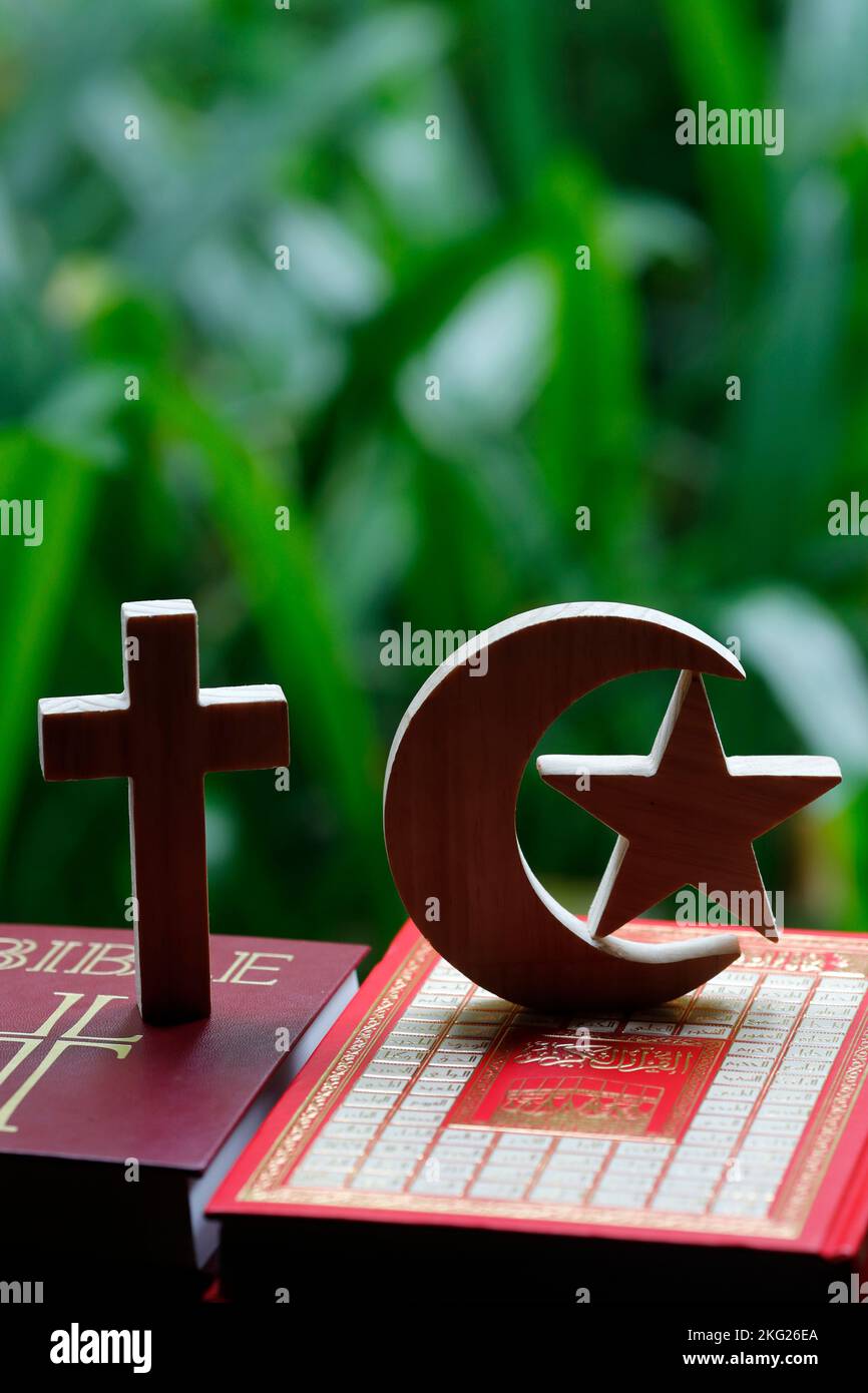 Simboli religiosi : Mezzaluna musulmana e Stella con Corano, e Croce di Cristina con la Bibbia. Concetto di dialogo interreligioso o interreligioso. Foto Stock