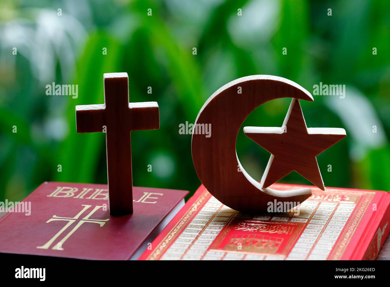 Simboli religiosi : Mezzaluna musulmana e Stella con Corano, e Croce di Cristina con la Bibbia. Concetto di dialogo interreligioso o interreligioso. Foto Stock
