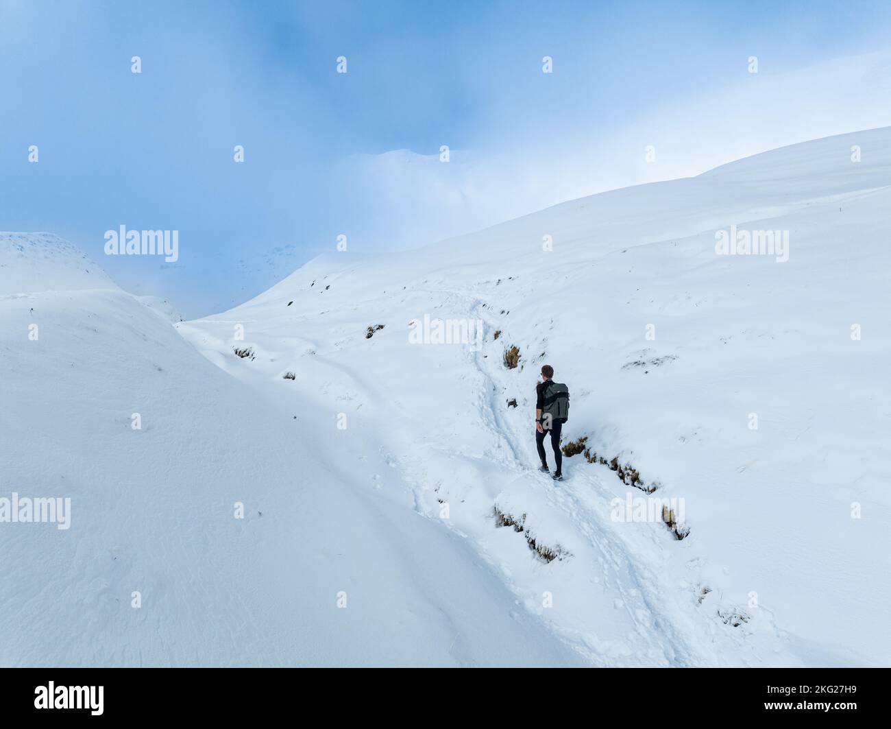 Un uomo individuale esplora la zona di montagna di neve in inverno Foto Stock