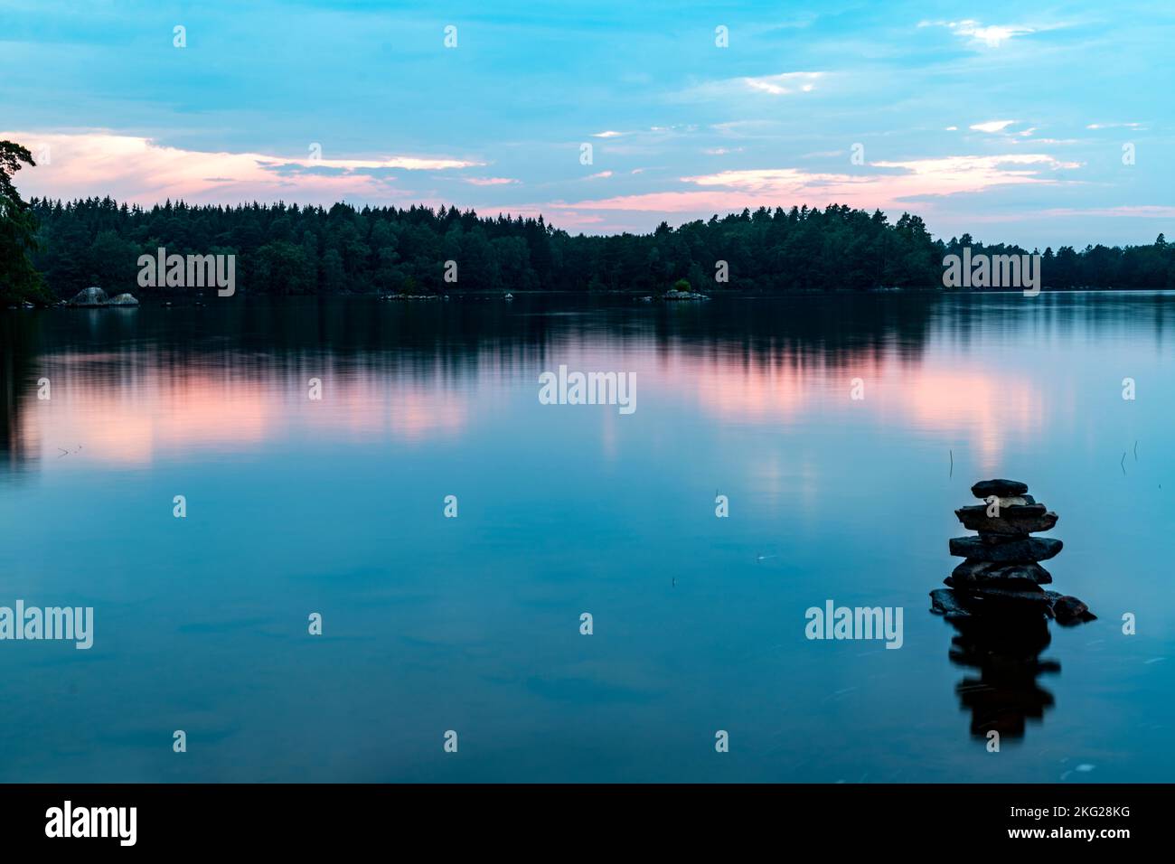 Il cielo nuvoloso sul lago calmo catturato al tramonto Foto Stock
