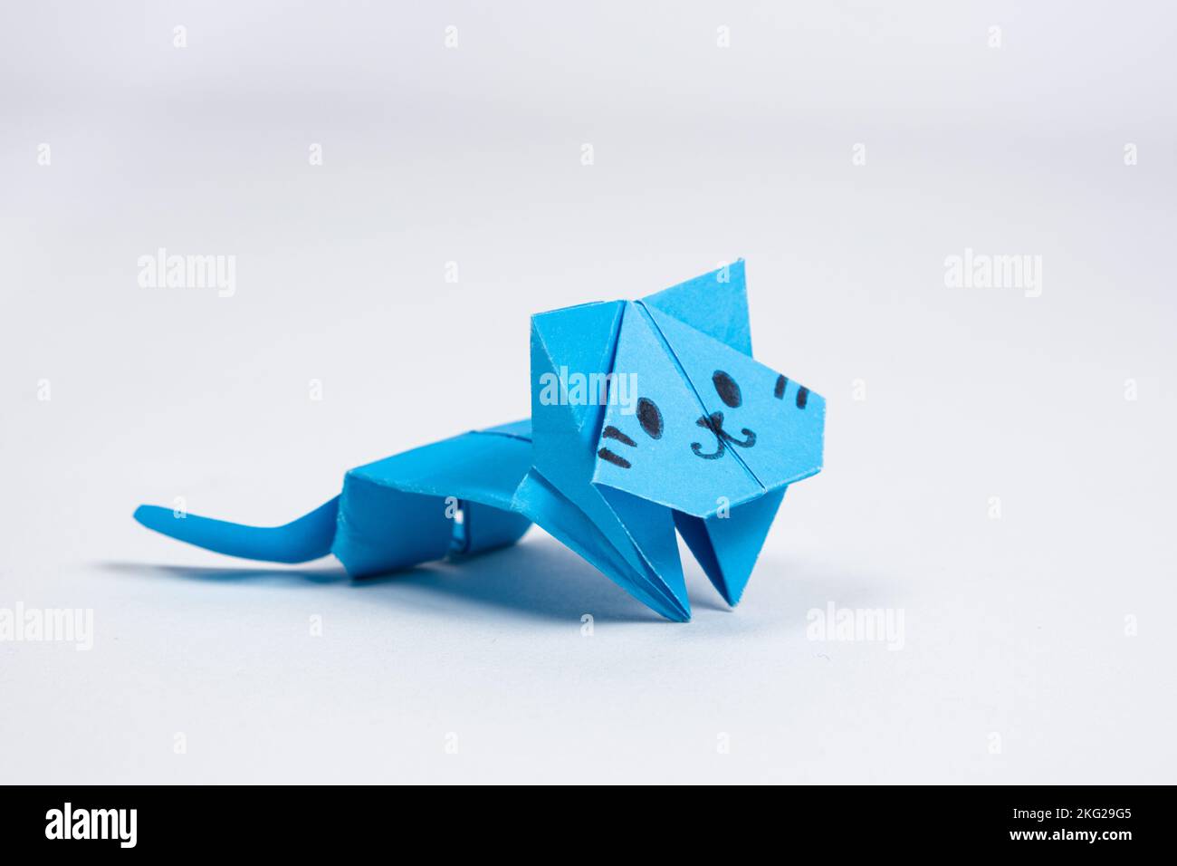 Gatto di carta origami blu, artigianato per bambini e adulti, figurine di animali fai da te, sfondo bianco Foto Stock