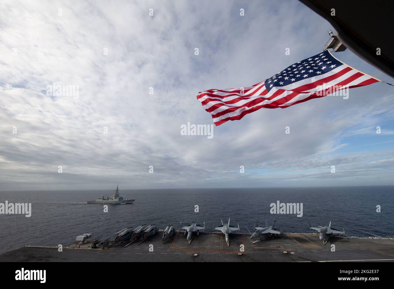 La prima portaerei della classe USS Gerald R. Ford (CVN 78) vola la bandiera americana durante le vacanze mentre fuma in formazione con la fregata spagnola Armada Álvaro de Bazán (F 101), 25 ottobre 2022. Il gruppo GRFCSG (Gerald R. Ford Carrier Strike Group) è schierato nell'Oceano Atlantico, conducendo formazione e operazioni insieme agli alleati e ai partner della NATO per migliorare l'integrazione per le operazioni future e dimostrare l'impegno della Marina statunitense verso una regione atlantica pacifica, stabile e priva di conflitti. Foto Stock