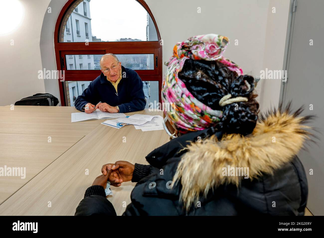 Volontari che aiutano un migrante con la sua ricerca di lavoro a la Maison Bakhita, Parigi, Francia Foto Stock