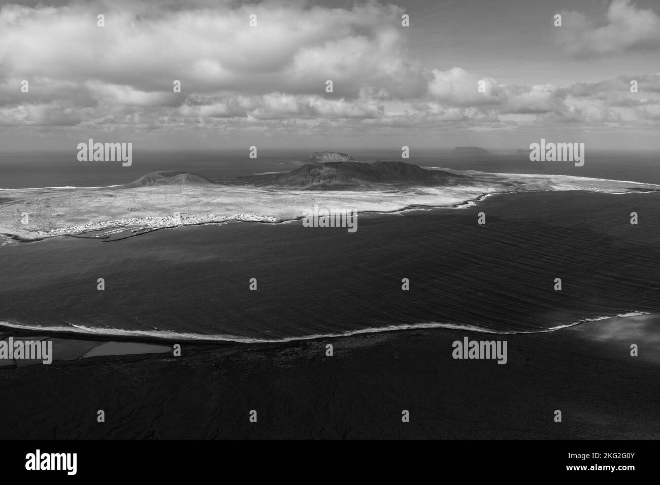 Bianco e nero con nuvole e onde infrangenti Foto Stock