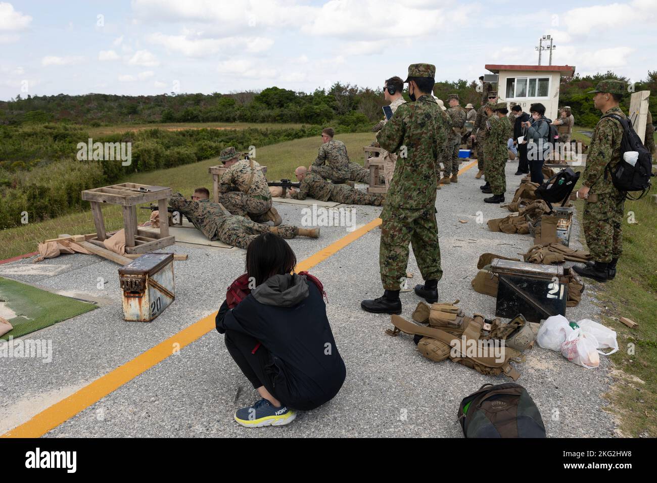 I Marines degli Stati Uniti con la III Marine Expeditionary Force, i membri della Ground Self-Defense Force del Giappone e i rappresentanti dei media di Okinawan, osservano un campo di fuoco vivo a Camp Hansen, Okinawa, Giappone, 25 ottobre 2022. III MEF ha ospitato un seminario sui media per i rappresentanti dei media di Okinawan per fornire una migliore comprensione di ciò che il III MEF fa al fine di migliorare le relazioni con la loro nazione ospitante. I rappresentanti dei media hanno avuto l'opportunità di volare su aerei militari, osservare le gamme di fuoco dal vivo e visitare il Jungle Warfare Training Center. Foto Stock