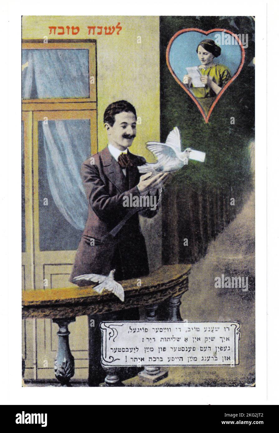 Un biglietto di auguri di Capodanno Yiddish dei primi anni del 20th° secolo con una riga (in alto) di ebraico. Con immagini di un uccello bianco che consegna il saluto. Foto Stock