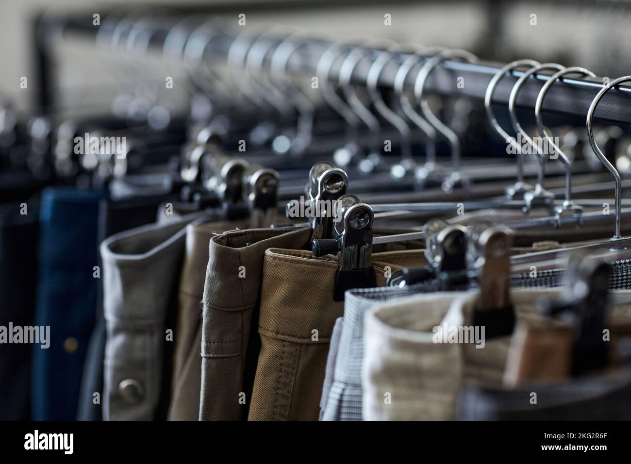 Primo piano di jeans e pantaloni in fila sul portabiti al negozio di seconda mano, spazio copia Foto Stock