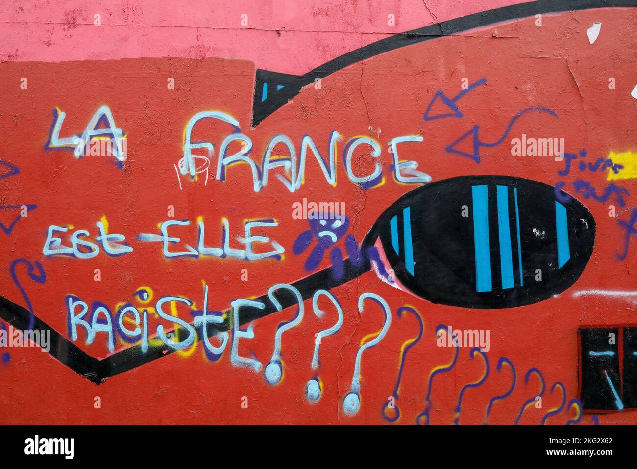 Muro di strada coperto di arte di strada e graffiti a Parigi, Francia. "Sono i razzisti francesi?" Foto Stock