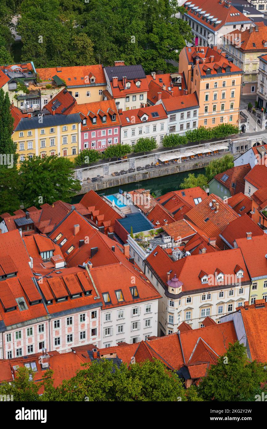 Città di Lubiana in Slovenia, vista sopra le case piastrellate rosse su entrambi i lati del fiume Lubiana nella città vecchia. Foto Stock