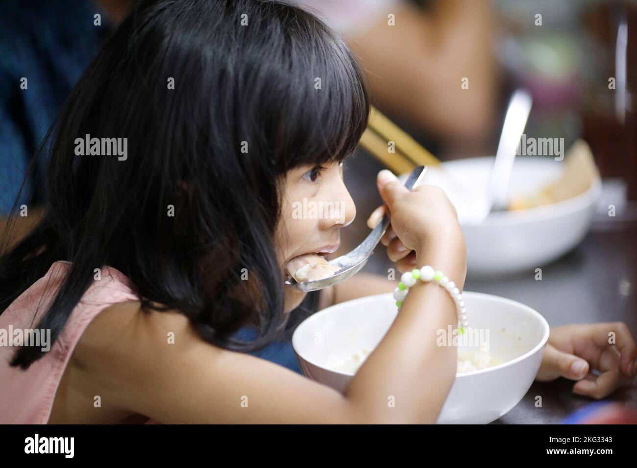 Giovane ragazza vietnamita che mangia il pranzo a casa. Hoi An. Vietnam. Foto Stock