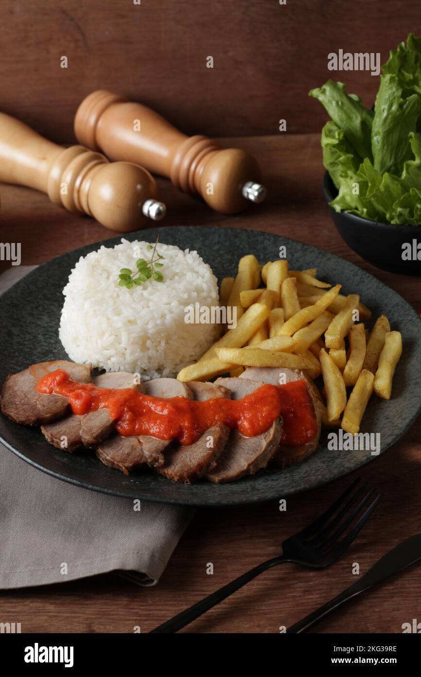 piatto di carne, riso e patatine fritte Foto Stock