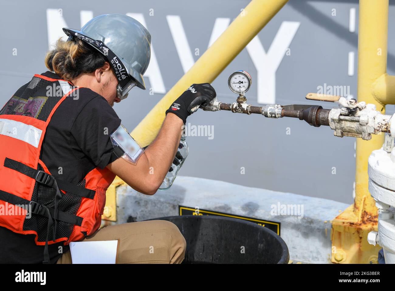 Naval Supply Systems Command Fleet Logistics Center dipendente di Pearl Harbor Lawsen Lee, addetto al sistema di distribuzione del carburante, versa un campione di F76 di carburante diesel marino durante un'operazione di disimballaggio a bordo della Joint base Pearl Harbor-Hickam (JBPHH), Hawaii, 27 ottobre 2022. L'operazione di disimballaggio rimuoverà circa un milione di galloni di carburante dalle tre tubazioni del carburante principali che collegano l'impianto di stoccaggio del carburante alla rinfusa (RHBFSF) di Red Hill ai punti del carburante sul JBPHH. JTF-RH è stato istituito dal Dipartimento della Difesa per garantire la dealimentazione sicura e rapida del RHBFSF. Foto Stock