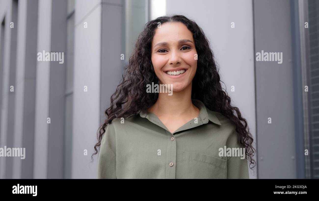 Vista posteriore da dietro donna irriconoscibile con capelli ricci scuri shampoo capelli stile. La signora caucasica Latina gira la testa girandosi verso la fotocamera Foto Stock